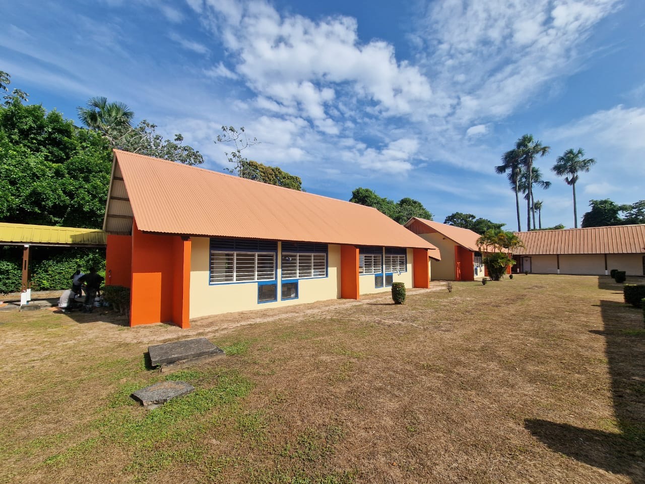 Réhabilitation de bâtiments scolaires à toiture orange et façades rénovées, Saint-Laurent